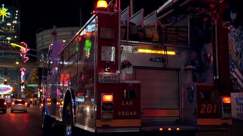 Las Vegas, Nevada / USA - October 1 2018: This video shows a fire truck in action with flashing lights in the middle of a busy night city setting. 