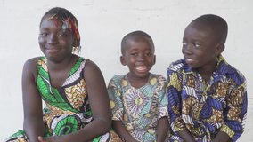 Portrait of three beautiful African black children smiling and laughing outdoors. 
