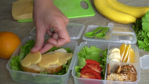 Packing a Zero Waste Lunch. Mother putting food in lunch box. Packing healthy lunches for child care, preschool, kinder or school