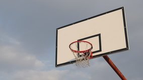 Basketball hoop with backboard against cloudy sky 4K footage