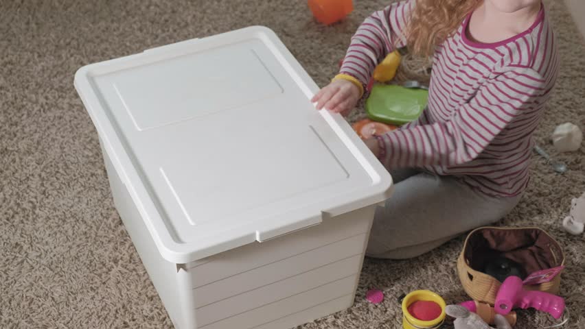 Lovely laughing little kid, preschool blonde, playing with colorful toys, sitting on the floor in the room 4k
