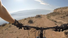 Man riding enduro mountain bike on rocky trail at the seaside in Croatia. View from first person perspective POV. Gimbal stabilized video.
