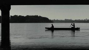 High definition video of two fishermen's silhouette on a boat in a cinematic sequence.