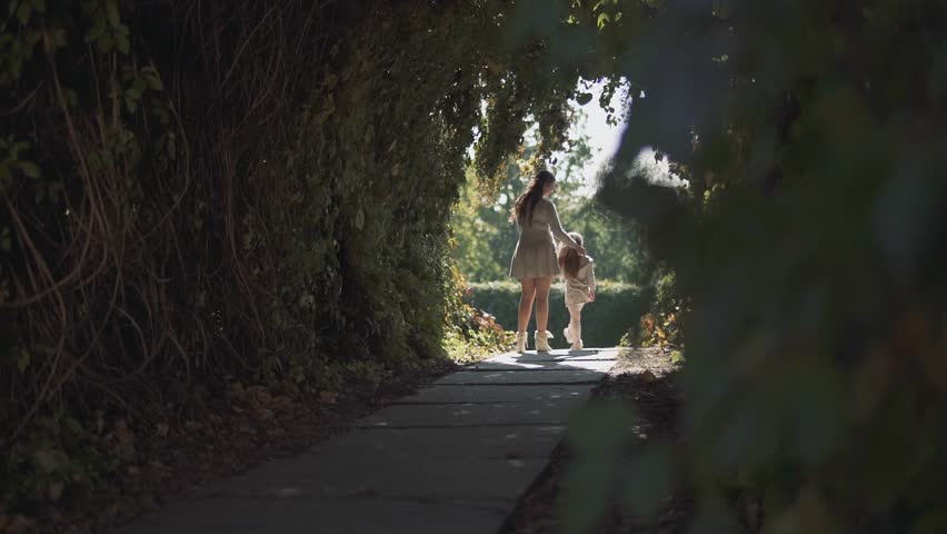 Mom and little girl are holding each other at the park
