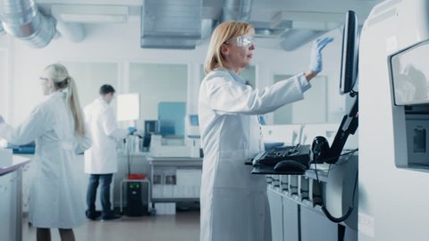 Team of Genetic Research Scientists Work with Medical Equipment, Analysing Test Tubes with Blood Samples, Using Computers and Developing Innovative Drugs for Pharmaceutical Industry.