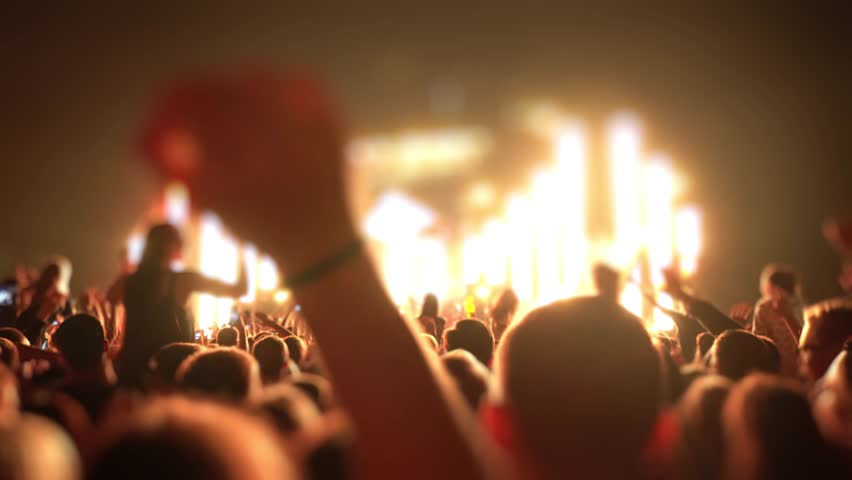 Happy people are watching an amazing musical concert. Merry fans jump and raise their hands up.
Crowd of excited fans applauding to popular band performing favorite song. A group of fans with phones | Shutterstock HD Video #1018316902