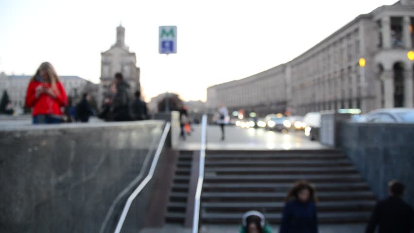 People moves in and out of underground pedestrian crossing. City street blurred view