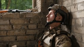 Stressed army soldier taking helmet off, covering face with hands after hard combat while sitting on ground. Tired of violence and fight special forces ranger sitting in deep depression after battle. - Powered by Shutterstock - Get 15% off with code: PIKWIZARD15