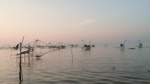 Footage of traditional fishing net in thailand with background during sunrise.