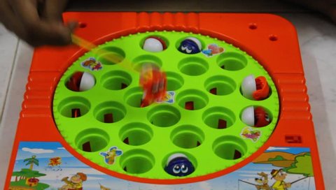 Chennai, Tamilnadu / India - 08 10 2018: Young girl child seen playing fish catching toy game