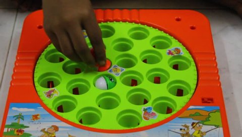 Chennai, Tamilnadu / India - 08 10 2018: Young girl child seen playing fish catching toy game