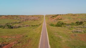 An aerial pull back video of a scenic highway in the Gypsum Hills in Kansas.