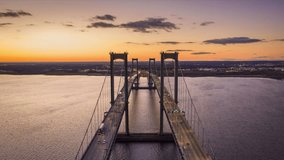 Aerial timelapse of Delaware Memorial Bridge at dusk. The Delaware Memorial Bridge is a set of twin suspension bridges crossing the Delaware River between the states of Delaware and New Jersey