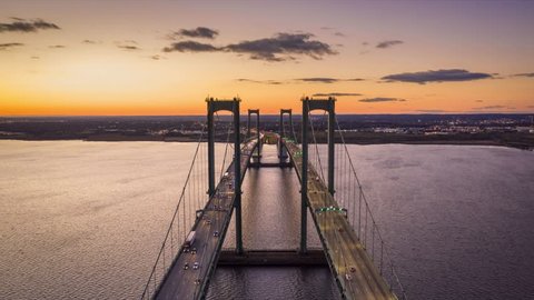 Aerial timelapse of Delaware Memorial Bridge at dusk. The Delaware Memorial Bridge is a set of twin suspension bridges crossing the Delaware River between the states of Delaware and New Jersey