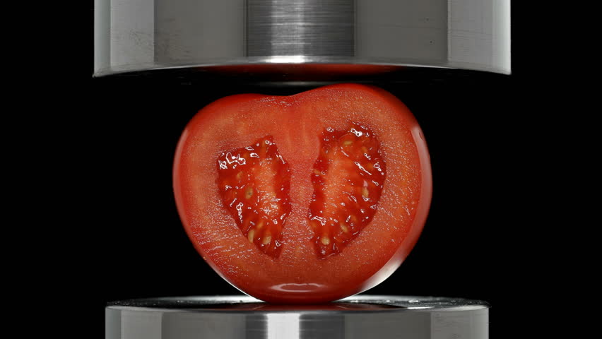 tomato sectioned under a hydraulic press, close-up Royalty-Free Stock Footage #1018365007