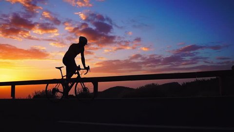 Silhouette of a cyclist at sunset in the mountains