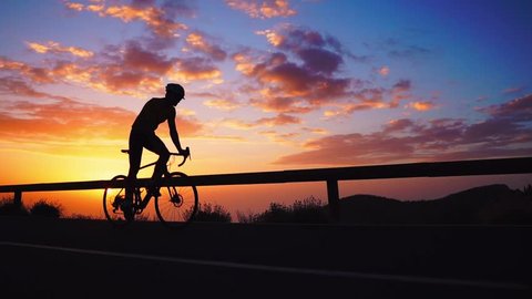 Silhouette of a cyclist at sunset in the mountains