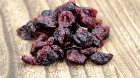 Dried cranberries rotate on wooden plate