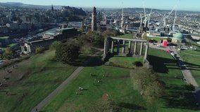 Aerial footage above Calton Hill. Ascending with view to the monuments, Princes Street, Castle and beyond. 