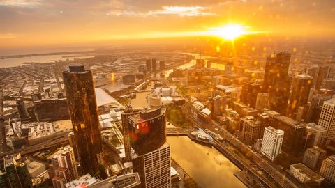 An aerial view of Melbourne cityscape including Yarra River and Victoria Harbour in the distance. Timelapse during sunset with beautiful sun ray bursting through fast moving clouds.
Timelapse Zoom In.