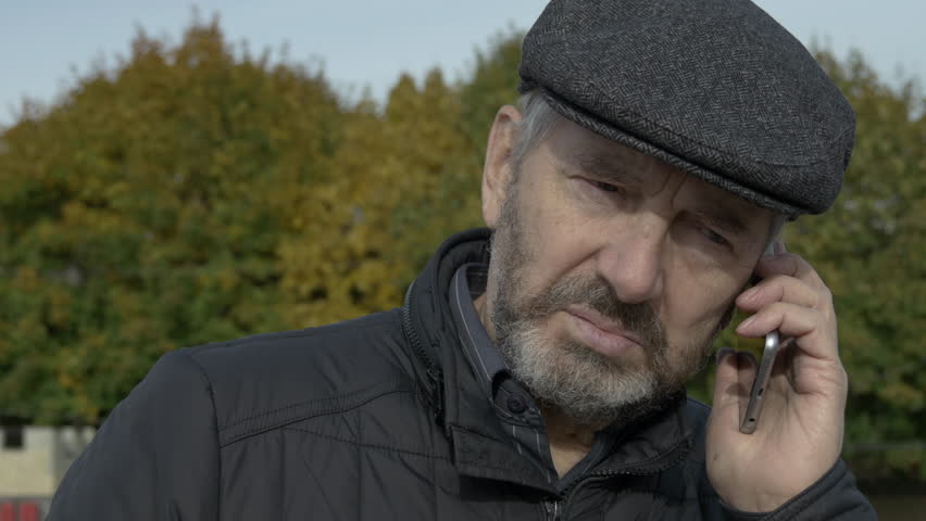 Elderly Bearded Man Talking On The Smartphone On The Street