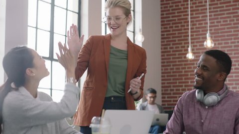 happy business people brainstorming caucasian team leader woman sharing ideas colleagues celebrating successful teamwork high five enjoying victory using laptop computer in multi ethnic office