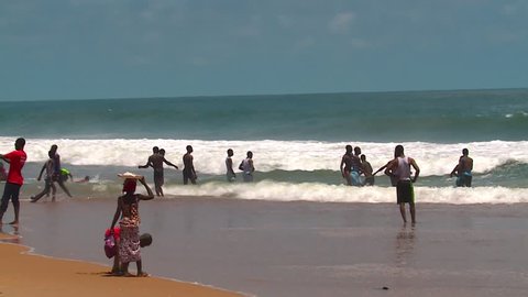 Grand Bassam, Cote d'Ivoire - 09 26 2016: GRAND BASSAM, IVORY COAST, AFRICA. SEPTEMBER 2016. Views of the famous Ivorian beach with people swimming
