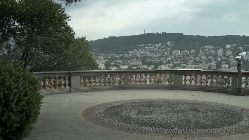 View point with binoculars in French luxury city of Nice. Cityscape on cloudy spring day. Concept of sightseeing and travel. Left to right pan real time establishing shot