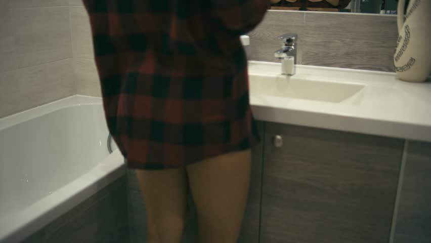 Woman in bathroom with lipstick doing makeup