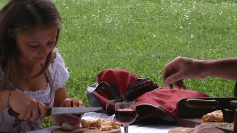 a teenager dressed in a typical Tyrolean dress eats some slices of bacon