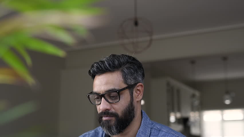 Portrait of an upset latin man working witj laptop. Mature businessman being depressed by working at home with computer. Multiethnic man feeling strain in eyes after working for long hours on computer Royalty-Free Stock Footage #1018420474