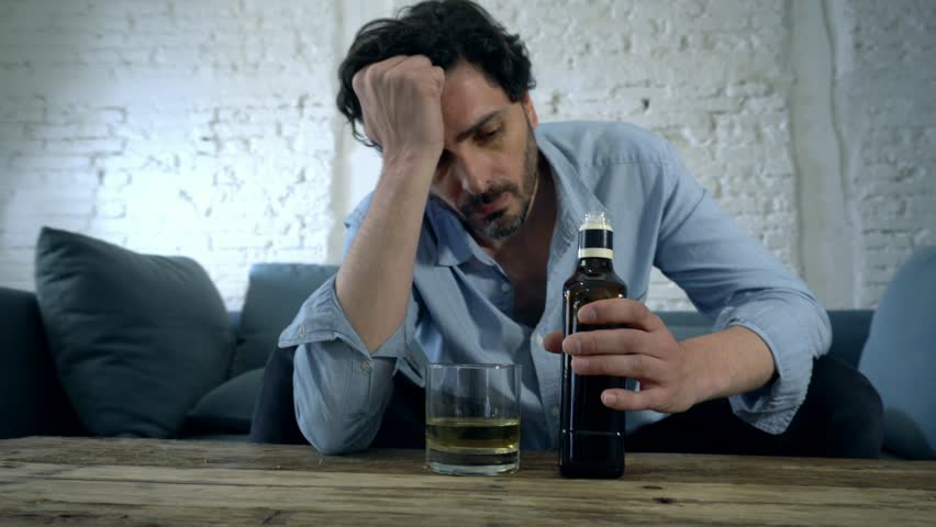 drunk alcoholic lain business man drinking whiskey from the bottle and glass depressed wasted and sad at home couch in alcohol abuse and alcoholism concept Royalty-Free Stock Footage #1018420594