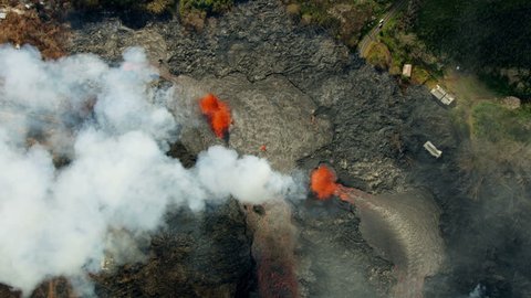 Aerial view of open fissures ejecting hot magma and toxic gases from earths crust destroying property lava rock solidifying Kilauea Hawaii USA RED WEAPON