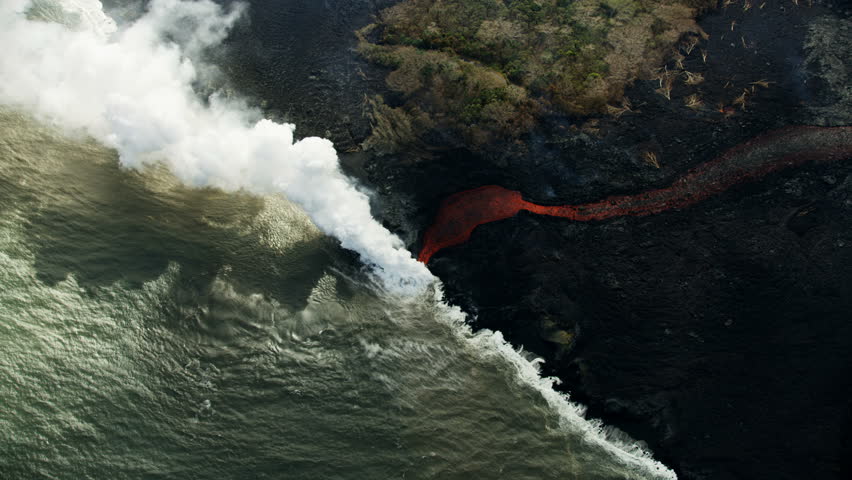 Aerial view fast flowing volcanic lava liquid flowing seaward producing clouds of toxic steam rising above the landscape new land created Kilauea Hawaii USA RED WEAPON