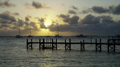 View of jetty and calm ocean with sailing boats in luxury travel destination at sunset Bahamas America RED WEAPON