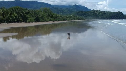 Happy young couple running the beach in Costa Rica, Uvita