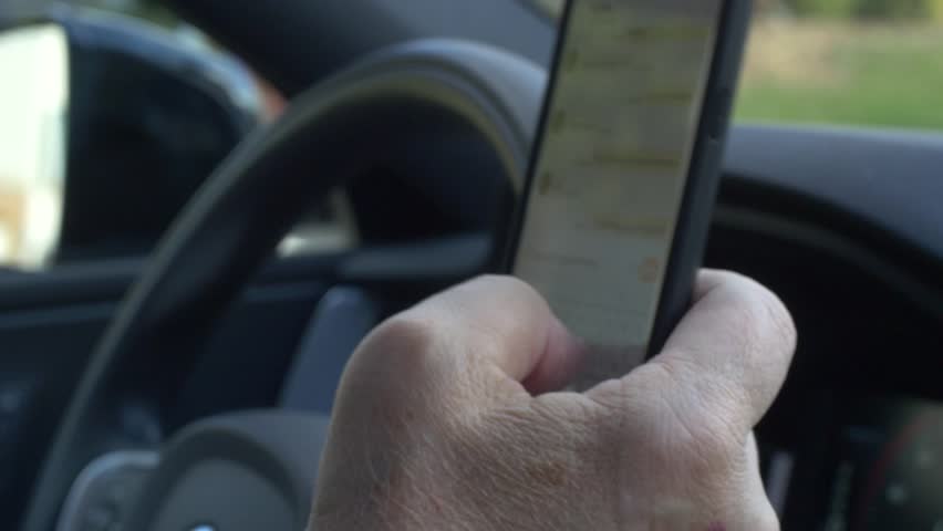 Driver texting behind the wheel Royalty-Free Stock Footage #1018434346