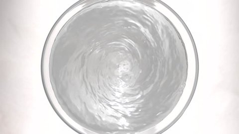 View footage of Medicine powder falling to water swirl in glass,  Slow motion