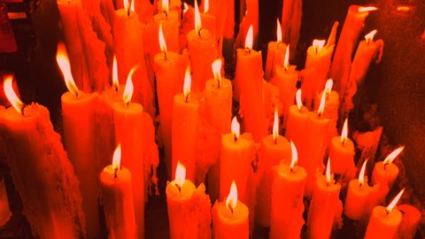 Red burning and dripping candles. Spooky. Horror. Hell. Halloween. Handheld shot with stabilized camera.