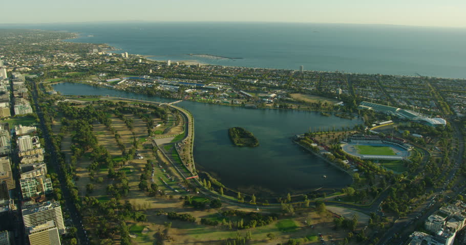 Aerial sunset view with sun flare Albert Park lake and Port Phillip Bay Melbourne Victoria Australia