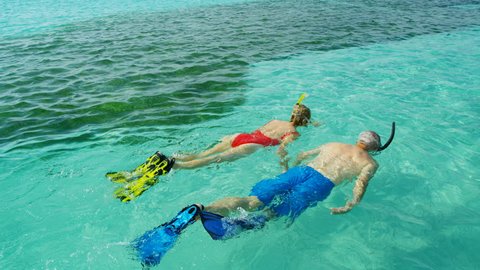 Active senior Caucasian American couple snorkeling and enjoying adventure Summer vacation swimming together in tropical ocean Bahamas USA RED WEAPON