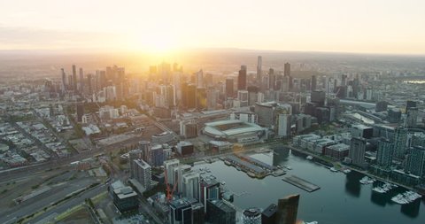 Aerial view at sunrise commercial skyscrapers of Melbourne CBD skyline and stadium Yarra River Victoria Australia