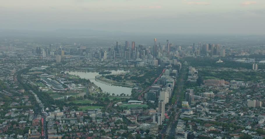 Aerial morning view over Albert Park and lake towards city skyscrapers of Melbourne Central Business District Victoria Australia
