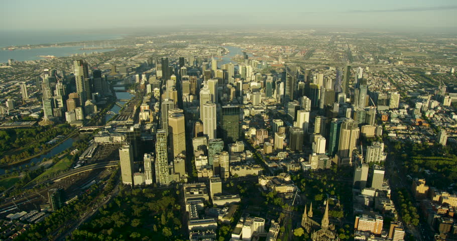 Aerial view across city skyscrapers of Melbourne central business district at sunrise to Port Phillip Bay Victoria Australia