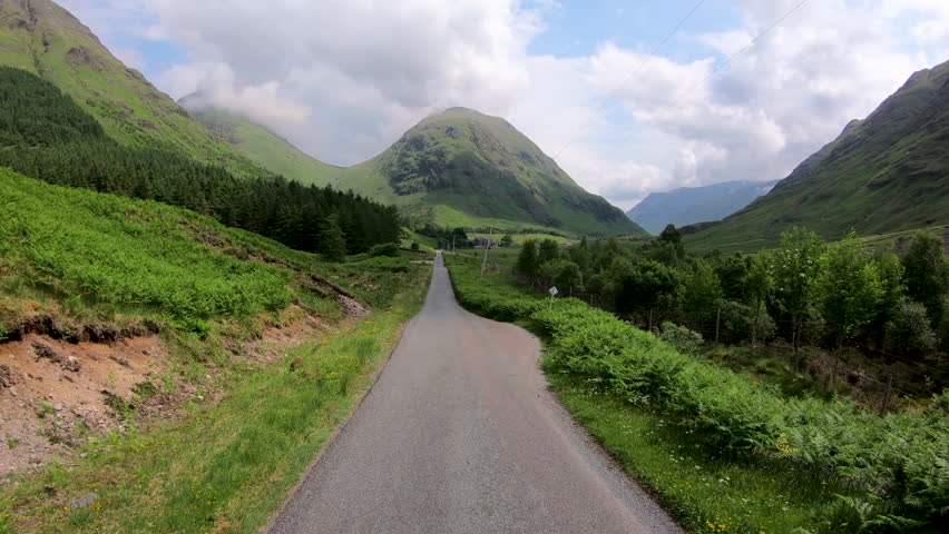 POV drive in Glen Etive mountain forest scenic evergreen pine trees Scottish highland landscape rural valley slopes wilderness Scotland UK Europe 