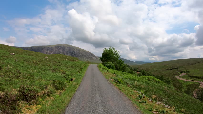 POV journey driving in Glen Etive scenic evergreen pine forest Scottish highland landscape mountain slopes rural valley wilderness Scotland UK Europe 