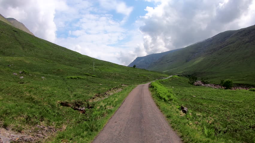 POV journey driving in Glen Etive scenic evergreen pine forest Scottish highland landscape mountain slopes rural valley wilderness Scotland UK Europe 
