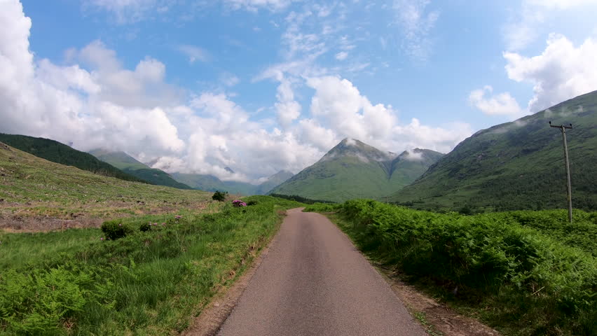 POV journey driving in Glen Etive scenic evergreen pine forest Scottish highland landscape mountain slopes rural valley wilderness Scotland UK Europe 