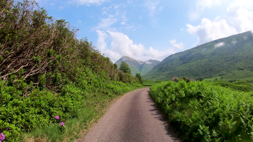 POV journey driving in Glen Etive scenic evergreen pine forest Scottish highland landscape mountain slopes rural valley wilderness Scotland UK Europe 