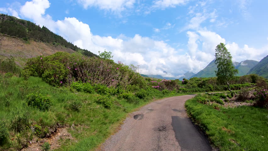 POV journey driving in Glen Etive scenic evergreen pine forest Scottish highland landscape mountain slopes rural valley wilderness Scotland UK Europe 